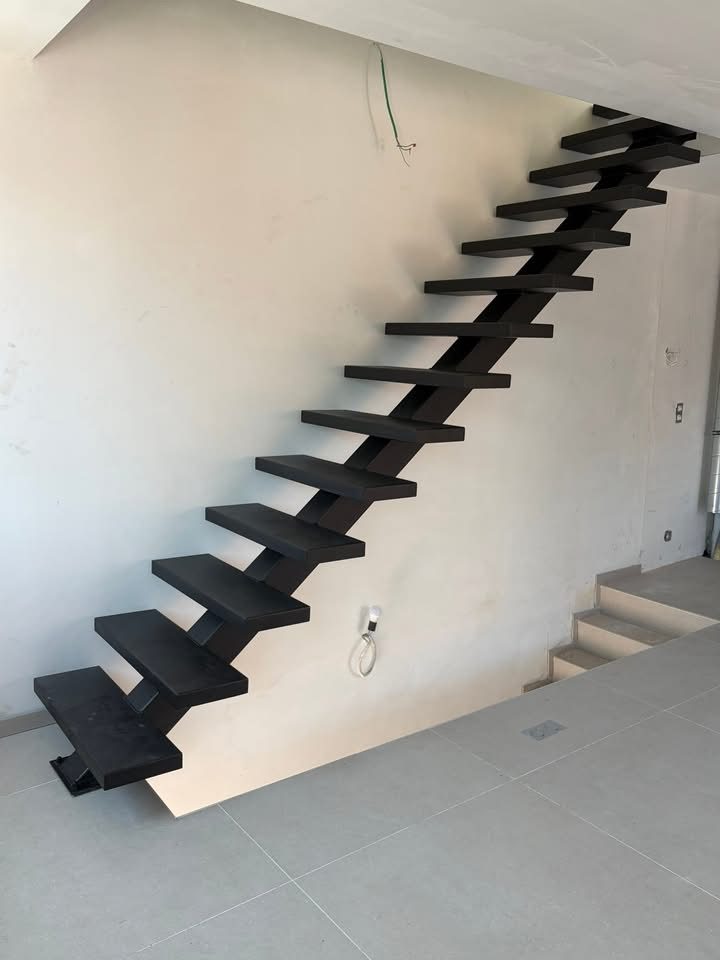 Escalier droit en acier noir à limon central et marches en tôle pliée