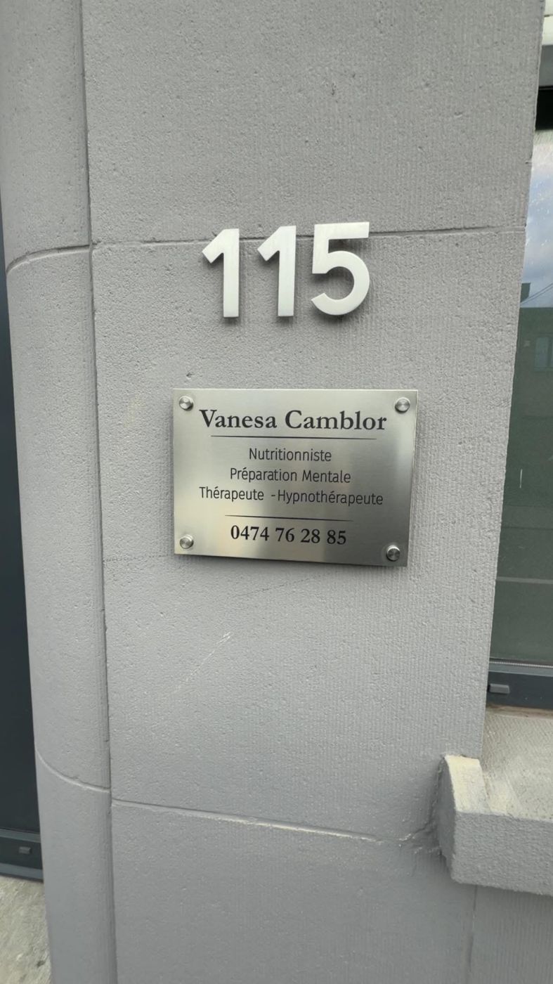 Plaque professionnelle en inox brossé fixée sur entretoises à côté d'une porte