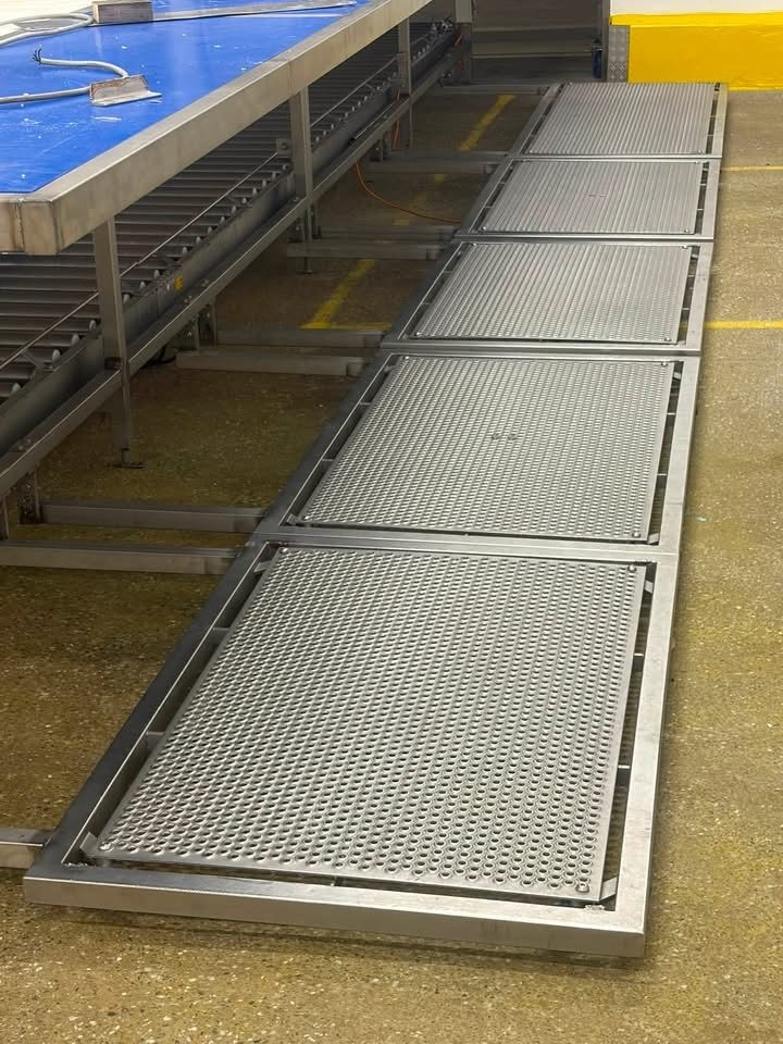 Rangée de plateformes en inox avec tôles perforées antidérapantes le long d'une ligne de production