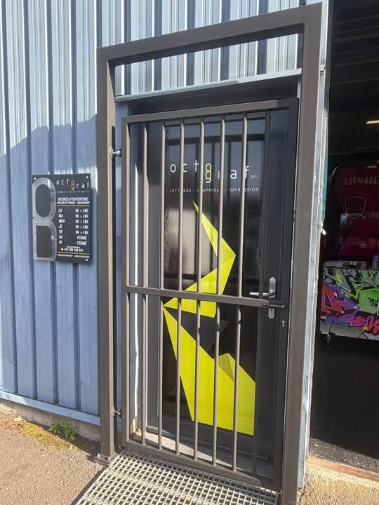 Porte grillagée de sécurité en acier posée à l'entrée d'un atelier