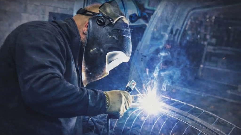 Le patron de Metalex soude un garde-corps cintré à l'atelier